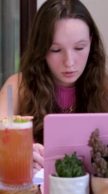 Oturma odasındaki kanepede uzanmış beyaz bir kadın boş vakit geçirmek için film ya da televizyon dizisi arıyor. İspanyol kız internetten film izlemeyi seçiyor. Omuz manzarasının üstünde.