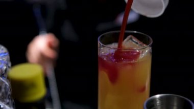 Viski bardağında, plajda, siyah zemin üzerinde su damlalarıyla yapılan seks. Yaklaş, alanın sığ derinliği. Aşçılık süreci adım adım