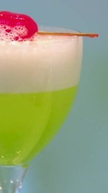 Cin, aperatif, likör, nane ve buzlu yeşil Negroni kokteyli. Şişeli turkuaz bar tezgahı arka planı