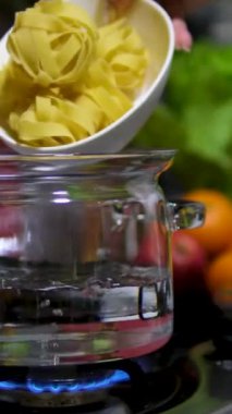 Hassas spagettiyi pişirmek için ince makarna yuvaları eklendiği için tencerede su kaynıyor. Yuva şeklinde ince spagetti erişteleri. Hazır şehriye. makarna yuvaları. Aşçılık süreci adım adım