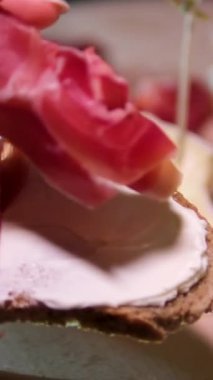 Bar vitrinlerinde sıradan bir sahne jambonla dolu bir sandviç, yanında da ahşap tezgahta bir bardak bira, rahat ve gayri resmi bir yemek deneyimini yansıtıyor. jambon birası
