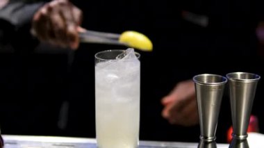 Barmen çalışıyor, bardaki açık hava partisinde farklı renkte içki kokteylleri içiyor, ve diğerleri şölende, barmen kulüpte içki ve içecekleri karıştırıyor.