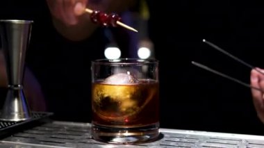 Eller, barmen ve limonlu kokteyl. İçki hazırlığı, içecek ve barda yakın çekim için. Alkol, cam ve barmen buzlu meyve dilimi ile eski moda viskiyi süslemek için dekor ya da sanat için.