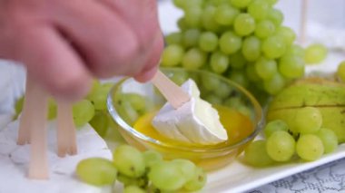 Çeşitli atıştırmalıklar. Peynir ve et panoları, fındık ve zeytin, balık, cips, kraker ve ekmek. Beyaz şarap ve gül, meyve ve böğürtlen. Mumlarla dolu şöminenin arka planında atıştırmalık bir masa.