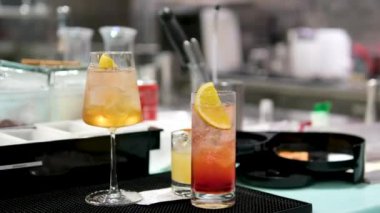 Profesyonel bir mutfağa yakın çekim yapmak, metal ölçü kabından bir kokteylin içine alkol dökmek.