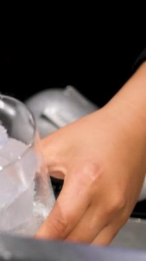 Alkollü içeceğin hazırlanması en başından servise kadar. Buz dökmek, sıvı ve soda karıştırmak, turuncu eklemek. Ellerini yaklaştır..