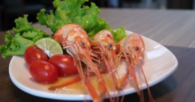 Izgara karides ve kediotu marulu beyaz bir porselen tabakta güzelce istiflenmiş. Mutfağa koşun. Protein açısından zengin bir balık yemeği. Selüloz. Diyet olsun. Çabuk evde sağlıklı yemekler pişir..