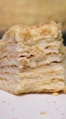 Çok katmanlı pasta, komik bir kaşıkla kesilmiş. Ekmek kırıntılarıyla süslenmiş puf böreği. Seçici odaklanma. Bir parça Napolyon keki.