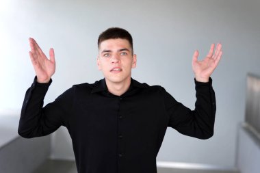 Hiçbir şeyden haberi olmayan, kafası karışık bir işçi Hindistanlı sıradan mavi kareli gömlek giyiyor omuzlarını silkiyor şaşkın bakışlı kamera ofiste bilgisayar başında bilgisayarla çalışıyor.