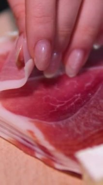 Prosciutto Crudo ya da jambon eti ya da kızarmış ekmeğin üzerinde İber jambonu dilimleri. El kızarmış ekmeğin üzerine bir dilim jambon koyar.. 