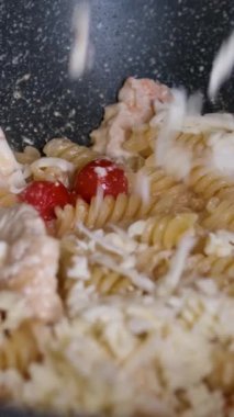 Kızartma tavasında makarna üzerine parmesan peyniri serp Carbonara tarifi rendelenmiş parmesan peyniri üzerine pastırmalı makarna ve kızartma tavasına karabiber serp.