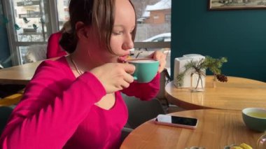 Elinde cep telefonuyla kahve ya da çay içen sevimli genç bir kadın. Mutfakta biriyle sohbet ederken güzel kıvırcık kız. Olumlu mesaj aldıktan sonra Cherfuly gülümsüyor.. 