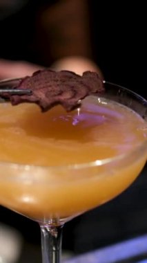 Barmen kokteylleri canlı, yenilebilir çiçeklerle süslüyor zarafet ve ayrıntıları yavaş çekimde gösteriyor.. 