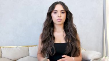 Gözlüklü zeki bayan öğrenci uzun süre cep telefonu kullandıktan sonra gözlerini dinlendiriyor. Genç kadın telefonu bir kenara koyuyor, gözlüklerini çıkarıyor, gözlerini ovalıyor. Telefonu bir kenara koyuyor.