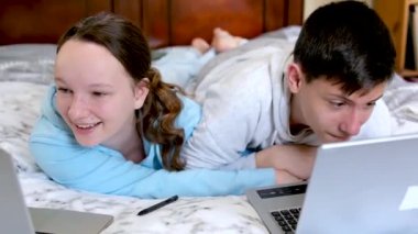 Mutlu Kafkasyalı çocuklar. Küçük kardeşler gülümsüyor. Aile babası, erkek kardeş, kız evlat. İnternette video izleyip çizgi film seyreden çocuklar. 