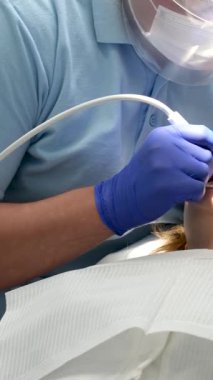 Ortodontist kadın hasta dişlerinin metal kısmını onarıyor. Kondilografiye hazırlanıyor. Alt çene eklemlerinin incelenmesi ve tedavisi. Ortodontoloji tedavisi ve tedavi konsepti. Dişçilik 