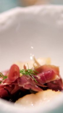 Jambonlu kuşkonmaz salatası ve haşlanmış yumurta. Jamon moleküler mutfağı olan çatal salatayla ye. Beyaz tabakta küçük porsiyonlar.