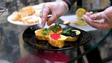 Rick havyar turna balığı havyarı ve somon kroketli sandviçler limonlu ve otlu sandviçe limon ekler. Yüksek kalite 4k görüntü