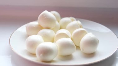 Çatalla taze mozzarella peyniri topları yiyorum.