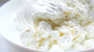 Bir kase süzme peynirli kaşık, çeşitli süt ürünleriyle servis ediliyor. Yüksek kalite 4k görüntü