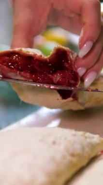 Kirazlı turta yapma süreci adım adım. Şekerci kadın tatil için lezzetli bir vişneli pasta hazırlıyor. Pastayı kes. Yemek tarifi, malzemeler, lavaş, yumurta yağı, kiraz dolumu, susam.