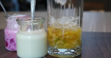 Yavaş yavaş soya sütü bir bardağa dökülüyor. Soya sütü ya da fasulye sütü bir cam bardağa dökülür. Soya sütü sağlıklı vejetaryenler için bitki bazlı bir içecek olarak kabul edilir. Asya sütü içeceği