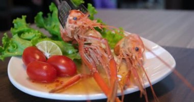 Düz bir tortilla üzerinde taze marul, domates, sos ve karides ile bir paket hazırlayan kadın elleri. Karides, marul, domates.