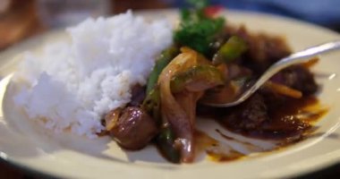 Ahşap arka planda, soslu ızgara biftek. Pişmiş pilav ve baharatlı soslu ızgara biftek. Yüksek kalite 4k görüntü
