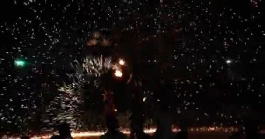 Siyah arka planda yanan meşaleleri olan bir sirk sanatçısının silueti, ateşli sanatçıların performansı. Gece yangını gösterisi. Sabit kamera hareketi 