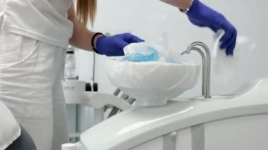 Kadın, dişçi asistanı ve muayenehane eldiveni ile hastane ya da oral bakım kliniğinde hazırlık prosedürü. Kadın, hemşire ve diş hijyenisti. Diş sağlığı kliniğinde temizlik