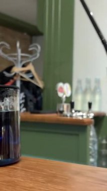 Kadınların kafede pipetle plastik bardaktan buzlu çay içmelerine yakın çekim. İki kadın bir kafede buzlu kahve içerken tartışıyor. Yüksek kalite 4k görüntü