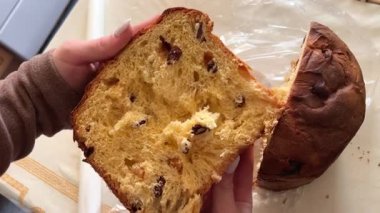 Panettone 'da dikey hareketle çekildi: masada duruyor, bir İtalyan hamur işi. Noel süsleri masayı süsler, kadeh kaldırmaya hazır bir bardak görebilirsiniz. 4k 