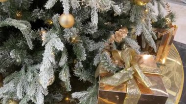 Bir Noel ağacını ışıltılı ışıklarla süslemek, renkli süsler ve eve tatil ruhunu getiren bir yıldızın olduğu neşeli bir sahne. Yüksek kalite 4k 