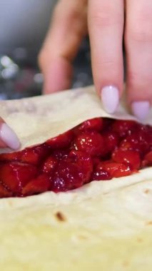 Yakından çekilen el yapımı böğürtlen ve çikolatalı krema yavaş çekimde gidiyor. Eldivenli tanınmayan bir kadın içeride lezzetli yemekler yapıyor. Yüksek kalite 4k görüntü