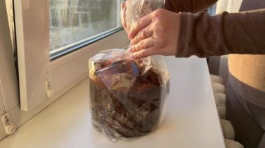 Panettone 'da dikey hareketle çekildi: masada duruyor, bir İtalyan hamur işi. Noel süsleri masayı süsler, kadeh kaldırmaya hazır bir bardak görebilirsiniz. 4k 