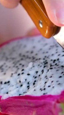 Pembe arka planda izole edilmiş bir tabakta iki yarım ejderha meyveli pitahaya. Yüksek kalite 4k görüntü