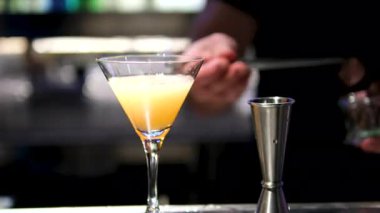 Bir barmen, tatilde bir ada tatil beldesindeki bir barda birden fazla tropikal kokteyl hazırlıyor. Sinematik ve güzel renkler. Çok sayıda malzeme ve aroma var..