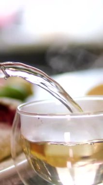 Yakından siyah çay dökülüyor, canlı sarı çaydanlık, samimi ortam. Sinema çay anı rahatlamanın özünü yakalıyor. Sinema detaylarıyla samimi ev ortamları, çay sergilenen gelenekler.. 