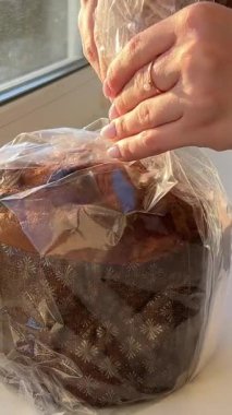 Panettone 'da dikey hareketle çekildi: masada duruyor, bir İtalyan hamur işi. Noel süsleri masayı süsler, kadeh kaldırmaya hazır bir bardak görebilirsiniz. 4k 