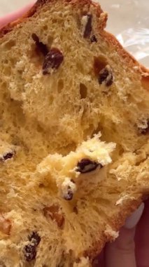 Panettone 'da dikey hareketle çekildi: masada duruyor, bir İtalyan hamur işi. Noel süsleri masayı süsler, kadeh kaldırmaya hazır bir bardak görebilirsiniz. 4k 