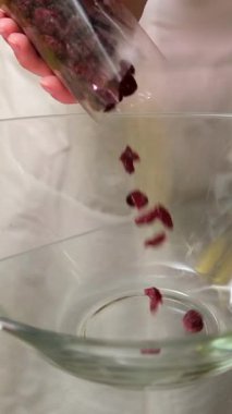 Sütlü çikolataların üzerine ağır çekimde kuru üzümler dökülüyor. Kurumuş meyveli cam bir tabağa kuru ananas kareleri dök.