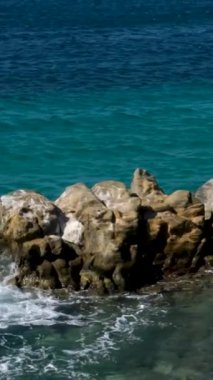 Baykal Gölü kıyısında duran kayalar. Kış mevsiminde buz gibi dalgalarla kayalık Olkhon Adası 'nın kayalık dağları Baykal Gölü' nün yanında. Yüksek kalite 4k görüntü