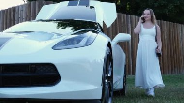 Genç, gülümseyen kızıl saçlı kadın arabasında cep telefonu kullanıyor. Yüksek kalite 4k görüntü