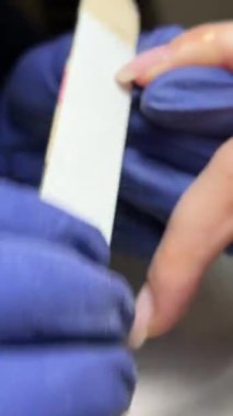 Kadın eli ve manikür aletleri, güzellik salonunda manikür yapma süreci. Güzellik salonunda çivi bakım prosedürü. Tırnak etlerini kesen yetenekli bir manikürcünün eldivenli elleri. Spa gövdesini kavra