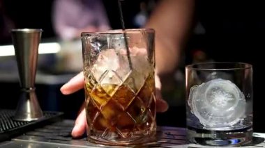 Parlak bir yaz kokteyli hazırlama süreci. İçinde portakal kabuğu özü de var. Barmen içkiye narenciye tazeliği vermek için kabuğu büker. Yüksek kalite 4k görüntü