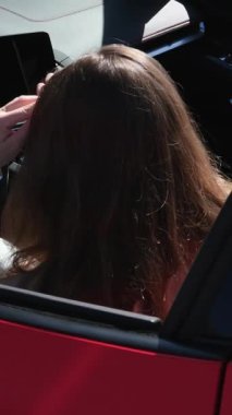 Genç, beyaz bir kadın, yol gezisinde kırmızı bir ciple güneşli bir sahil yolculuğunun tadını çıkarıyor. Neşeli ifadesi ve barış işareti kaygısız bir yolculuğun özünü yansıtıyor, ağır çekimde. Kırmızı kadın arabası.