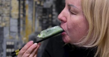 Kadın evdeki oturma odasında Vietnam böreği yiyor. Çekici, güzel bir kız masaya oturur, sabah evde sağlık için temiz aperatiflerin tadını çıkarır. Diyet ve Sağlıklı gıda konsepti. 4k