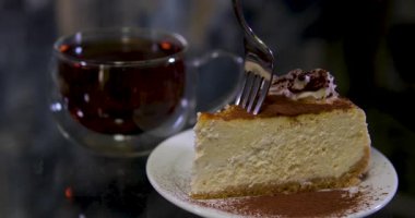Bir insan küçük bir çatalla Matcha Burt Cheesecake 'in tadını çıkarıyor. Yüksek kalite 4k görüntü