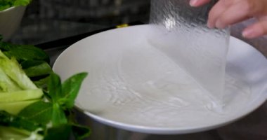 Kadın evdeki oturma odasında Vietnam böreği yiyor. Çekici, güzel bir kız masaya oturur, sabah evde sağlık için temiz aperatiflerin tadını çıkarır. Diyet ve Sağlıklı gıda konsepti. 4k