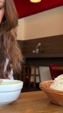 Kadın öğle yemeğinde çorba içiyor. Orta Asya ve Kafkas mutfağı. 4 bin. Yüksek kalite 4k görüntü